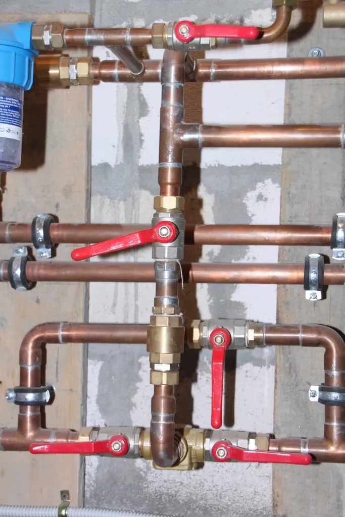 Copper water supply lines with red shut-off valves